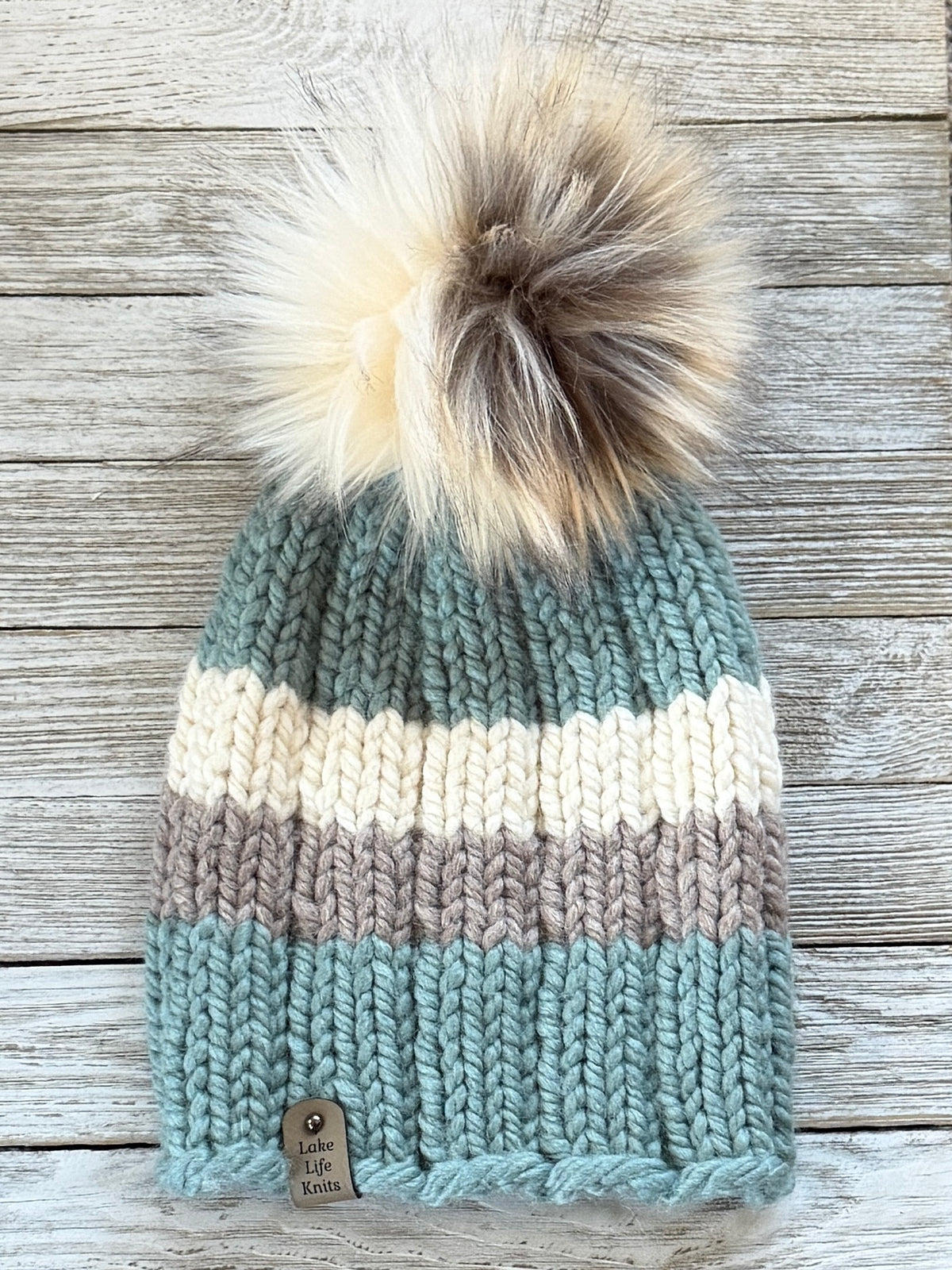 Succulent green, cream, and taupe striped knit beanie with a cream-and-brown faux-fur pom